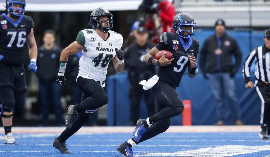 Boise State quarterback Jaylon Henderson, right, scrambles away from Hawaii defensive lineman Derek Thomas, left, during the first half of an NCAA college football game for the Mountain West Championship Saturday, Dec. 7, 2019, in Boise, Idaho. (AP Photo/Steve Conner)