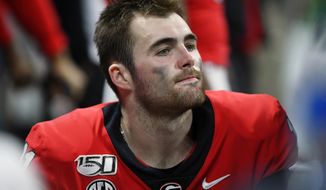 Georgia quarterback Jake Fromm sits on the bench after the Southeastern Conference championship NCAA college football game against LSU, Saturday, Dec. 7, 2019, in Atlanta. LSU won 37-10. (AP Photo/John Amis)