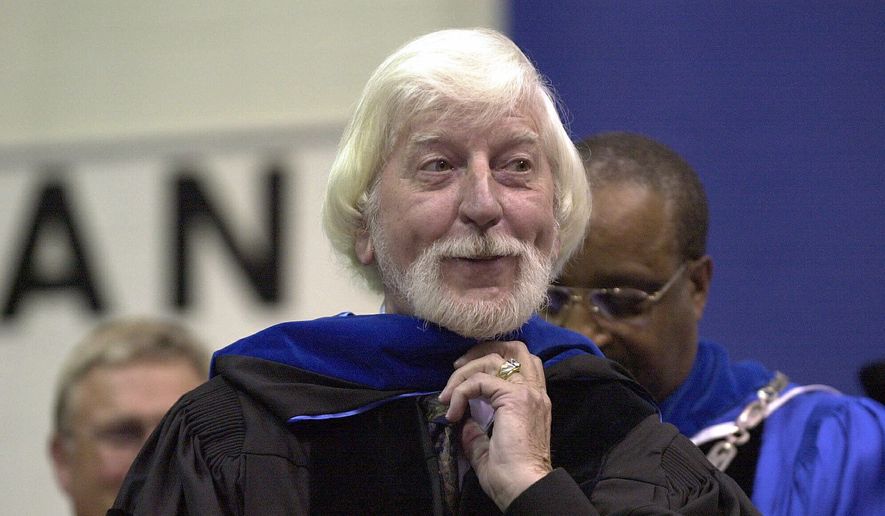In a May 21, 2000, file photo, Carroll Spinney, center, best known for his TV character "Big Bird" from Sesame Street, receives an honorary doctor of Humane Letters degree from Eastern Connecticut State University President David G. Carter, right, during commencement in Willimantic, Conn. Spinney, who gave Big Bird his warmth and Oscar the Grouch his growl for nearly 50 years on “Sesame Street,” died Sunday, Dec. 8, 2019, at his home in Connecticut, according to the Sesame Workshop. He was 85. (AP Photo/Steve Miller, File)