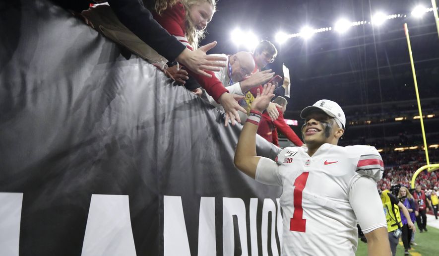 Ohio State quarterback Justin Fields (1) celebrates with fans following the team's Big Ten championship NCAA college football game against Wisconsin, early Sunday, Dec. 8, 2019, in Indianapolis. Ohio State won 34-21. (AP Photo/Michael Conroy)