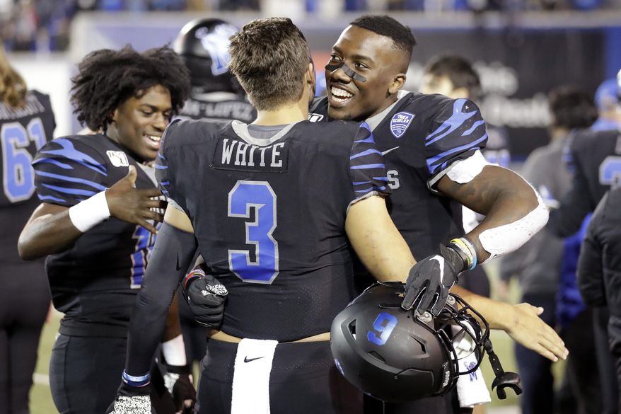 Memphis quarterback Brady White (3) hugs running back Patrick Taylor Jr. in the final minutes of the fourth quarter of an NCAA college football game against Cincinnati, Friday, Nov. 29, 2019, in Memphis, Tenn. (AP Photo/Mark Humphrey)
