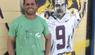 Artist Ken Lemoine stands in front of the Joe Burrow mural he and fellow artist Korey Scanova are painting on the side of Lemoine&#39;s business, Lemoine&#39;s Mid-City Daiquiris on Government Street in Baton Rouge, La. (Robin Miller/The Advocate via AP)