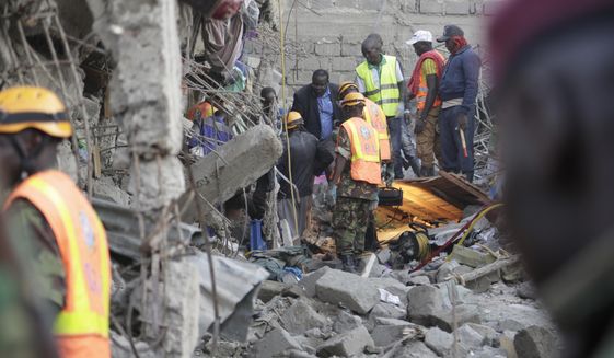 People and rescue workers attend the scene of a building that collapsed in Tasia Embakasi, an east neighbourhood of Nairobi, Kenya on Friday Dec. 6, 2019. A six-story building collapsed in Kenya&#39;s capital on Friday, officials said, with people feared to be trapped in the debris. Police say people have been rescued by residents using their bare hands. (AP Photo/Khalil Senosi)