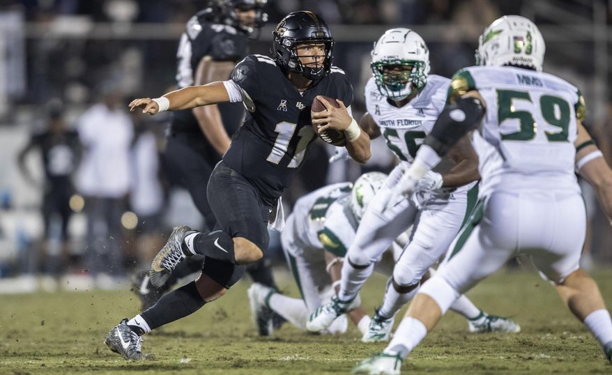 Central Florida quarterback Dillon Gabriel (11) sprints away from the South Florida defense during the second half of an NCAA college football game Friday, Nov. 29, 2019, in Orlando, Fla. (AP Photo/Willie J. Allen Jr.)