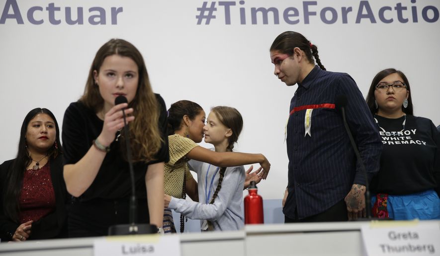 Climate activist Greta Thunberg, centre right, embraces another young activist at the COP25 Climate summit in Madrid, Spain, Monday, Dec. 9, 2019. Thunberg is in Madrid where a global U.N. sponsored climate change conference is taking place. (AP Photo/Andrea Comas)
