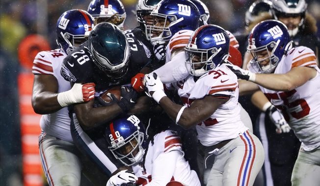 Philadelphia Eagles' Jay Ajayi (28) is tackled by New York Giants' Dalvin Tomlinson (94), Janoris Jenkins (20), Corey Ballentine (25) and Michael Thomas (31) during the first half of an NFL football game against the New York Giants, Monday, Dec. 9, 2019, in Philadelphia. (AP Photo/Matt Rourke)