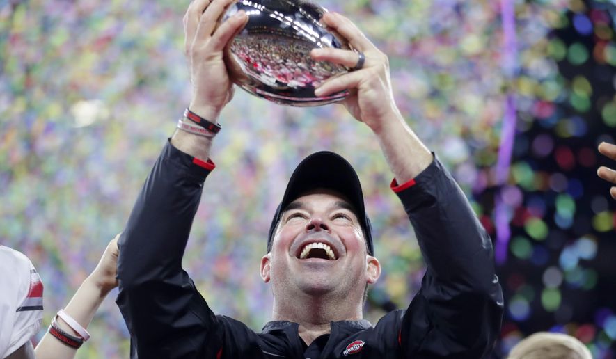 Ohio State coach Ryan Day holds the trophy following the team's 34-21 win over Wisconsin in the Big Ten championship NCAA college football game, early Sunday, Dec. 8, 2019, in Indianapolis. (AP Photo/Michael Conroy)