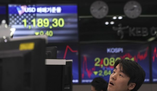 A currency trader watches computer monitors near the screens showing the Korea Composite Stock Price Index (KOSPI), right, and the foreign exchange rate between U.S. dollar and South Korean won at the foreign exchange dealing room in Seoul, South Korea, Tuesday, Dec. 10, 2019. Asian stock markets have fallen as investors look ahead to interest rate decisions by U.S. and European central bankers and possible American tariff hike on Chinese imports. (AP Photo/Lee Jin-man)