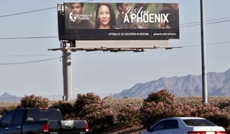 In this Nov 24, 2009, file photo, a University of Phoenix billboard is shown in Chandler, Ariz. The University of Phoenix for-profit college and its parent company will pay $50 million and cancel $141 million in student debt to settle allegations of deceptive advertisement brought by the Federal Trade Commission. (AP Photo/Matt York, File)