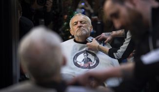 FILE - In this Saturday, Dec. 7, 2019 file photo Labour Party leader Jeremy Corbyn has his beard trimmed in Big Mel&#39;s Barbershop, Carmarthen, while on the General Election campaign trail in Wales. (Victoria Jones/PA via AP, File)