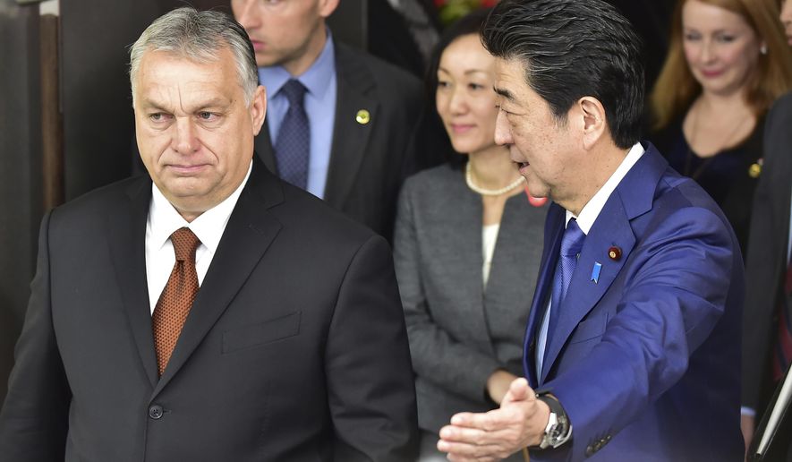 Japan's Prime Minister Shinzo Abe, right, escorts Hungary's Prime Minister Viktor Orban prior to their meeting at his office Friday, Dec. 6, 2019, in Tokyo. (Photo by Kazuhiro Nogi/Pool Photo via AP)