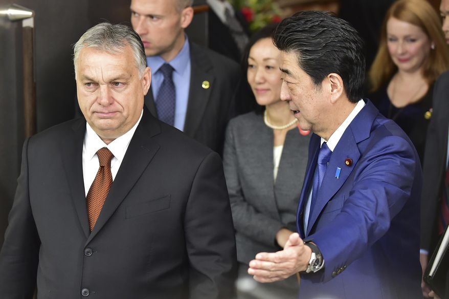Japan's Prime Minister Shinzo Abe, right, escorts Hungary's Prime Minister Viktor Orban prior to their meeting at his office Friday, Dec. 6, 2019, in Tokyo. (Photo by Kazuhiro Nogi/Pool Photo via AP)