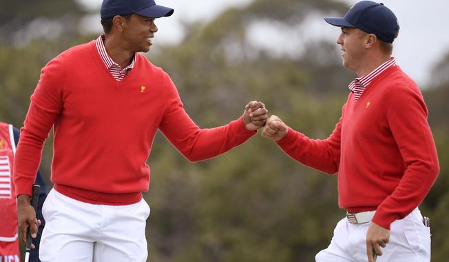 U.S. team player and captain Tiger Woods, left, and teammate Justin Thomas celebrate after Woods birdied the 5th during their fourball match at the Royal Melbourne Golf Club in the opening rounds of the President&#x27;s Cup golf tournament in Melbourne, Thursday, Dec. 12, 2019. (AP Photo/Andy Brownbill)