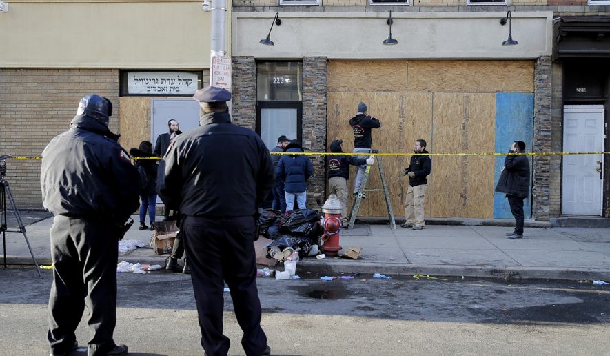 People board up the front of a kosher supermarket thats was the site of a gun battle in Jersey City, N.J., Wednesday, Dec. 11, 2019. The two gunmen in a furious firefight that left multiple people dead in Jersey City clearly targeted the Jewish market, the mayor said Wednesday, amid growing suspicions the bloodshed was an anti-Semitic attack. (AP Photo/Seth Wenig)