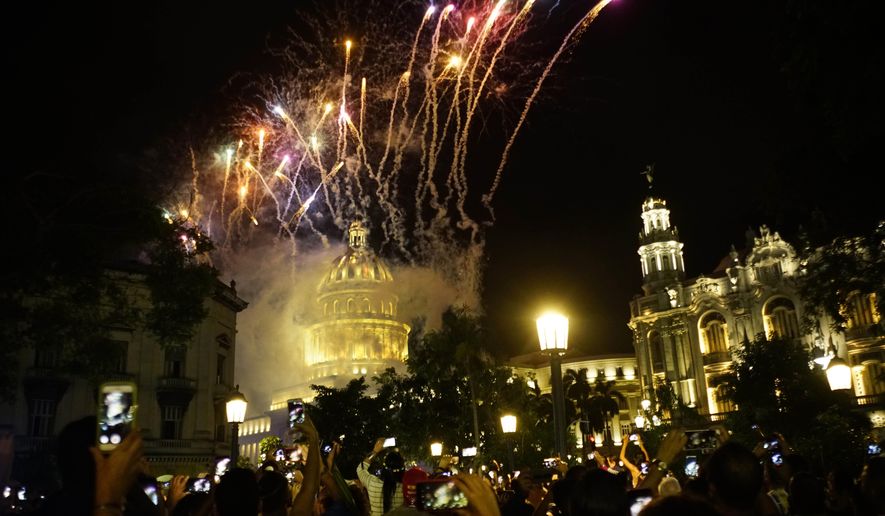 People take pictures of the fireworks at the Capitol during a gala as part of the celebration of the 500 years of the city in Havana, Cuba, Saturday, Nov. 16, 2019. Havana celebrates its 500th anniversary, a milestone event that has sparked reflection in the country, as it faces increasingly tense relations with the U.S. and serious economic challenges. (AP Photo/Ramon Espinosa)