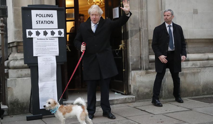 Britain's Prime Minister and Conservative Party leader Boris Johnson with his dog Dilyn as he leaves after voting in the general election at Methodist Central Hall, Westminster, London, Thursday, Dec. 12, 2019. The general election in Britain on Thursday will bring a new Parliament to power and may lead to a change at the top if Prime Minister Boris Johnson's Conservative Party doesn't fare well with voters. Johnson called the early election in hopes of gaining lawmakers to support his Brexit policy. (AP Photo/Frank Augstein)