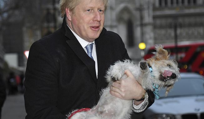 Britain&#x27;s Prime Minister and Conservative Party leader Boris Johnson holds his dog Dilyn after voting in the general election at Methodist Central Hall, Westminster, London, Thursday Dec. 12, 2019.  Dogs wait outside while their owners go into polling stations to cast their ballot in a general election Thursday Dec. 12, 2019.  U.K. voters are deciding Thursday who they want to resolve the stalemate over Brexit in a parliamentary election widely seen as one of the most decisive in modern times. (AP Photo/Alberto Pezzali)