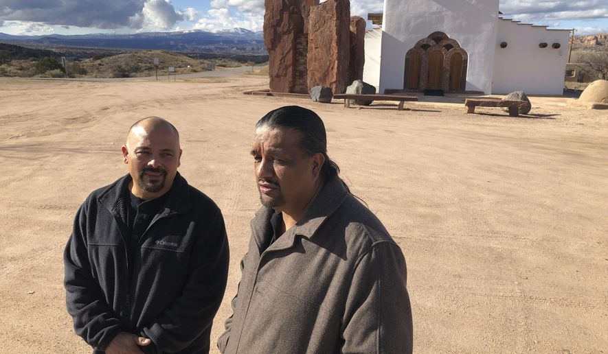 In this Dec. 9, 2019 photo, Santa Fe County Commissioner Henry Roybal, left, and Pojoaque Pueblo special projects coordinator Gabriel Montoya, right, pose for a photo near a nondenominational sanctuary in Pojoaque, N.M. As the 2020 census approaches, an Associated Press analysis of government data has found that about 41% of New Mexico residents live in hard-to-count areas —the largest proportion of any state in the nation. Roybal recruited Montoya as a trusted voice in the Native American community to promote census participation, which could help with the allocation of $1.5 trillion in federal spending. (AP Photo/Morgan Lee)