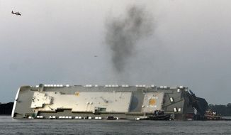 In a Sunday, Sept. 8, 2019 file photo, smoke rises from a cargo ship that capsized in the St. Simons Island, Georgia sound. Crews have finished draining all of the fuel from an overturned cargo ship three months after it capsized off the coast of Georgia, the team overseeing salvage operations said Thursday, Dec. 12, 2019. (Bobby Haven/The Brunswick News via AP, File) **FILE**