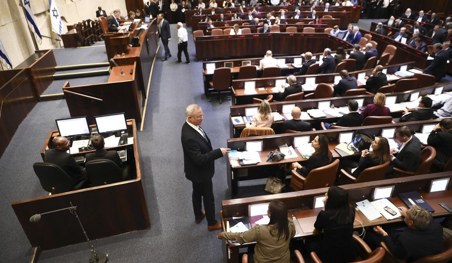 Blue and White party leader Benny Gantz, center, stands during a Knesset session in Jerusalem, Wednesday, Dec. 11, 2019. The Israeli parliament began voting to dissolve itself on Wednesday and pave the path to an unprecedented third election within a year. (AP Photo/Oded Balilty)