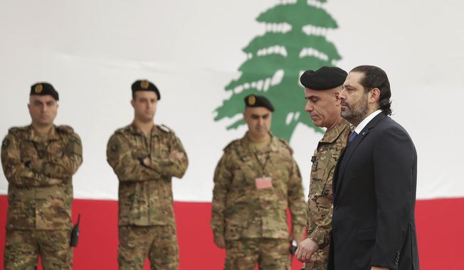 Resigned Lebanese Prime Minister Saad, right, arrives to attend a military parade to mark the 76th anniversary of Lebanon&#x27;s independence from France at the Lebanese Defense Ministry, in Yarzeh near Beirut, Lebanon, Friday, Nov. 22, 2019. Lebanon&#x27;s top politicians attended the military parade,  appearing for the first time since the government resigned amid nationwide protests now in their second month. (AP Photo/Hassan Ammar)