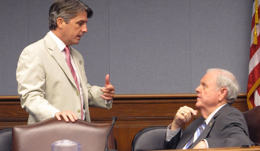 File-This June 19, 2018, file photo shows appropriations Chairman Cameron Henry, R-Metairie, standing, speaks with Rep. Charles "Bubba" Chaney, R-Rayville, in the House Appropriations Committee in Baton Rouge, La. Louisiana's income forecasting panel is expected Thursday, Dec. 12, 2019, to revise its forecasts for the upcoming budget year, possibly giving the governor and lawmakers more money to spend on an ever-growing list of proposals. (AP Photo/Melinda Deslatte, File)