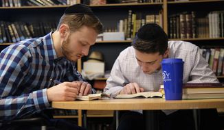 Yeshiva University students Aaron Heideman, left, and Marc Shapiro study in the university&#x27;s library in New York, Thursday, Dec. 12, 2019. They praised President Donald Trump&#x27;s executive order to expand the scope of potential anti-Semitism complaints on U.S. college campuses. They said they worry that friends attending other universities might be targeted by anti-Semitic attacks and that this could help protect them. (AP Photo/Luis Andres Henao)
