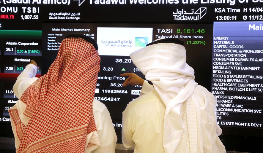 Saudi stock market officials watch the market screen displaying Saudi Arabia&#39;s state-owned oil company Aramco after the debut of Aramco&#39;s initial public offering (IPO) on the Riyadh&#39;s stock market in Riyadh, Saudi Arabia, Wednesday, Dec. 11, 2019. (AP Photo/Amr Nabil)