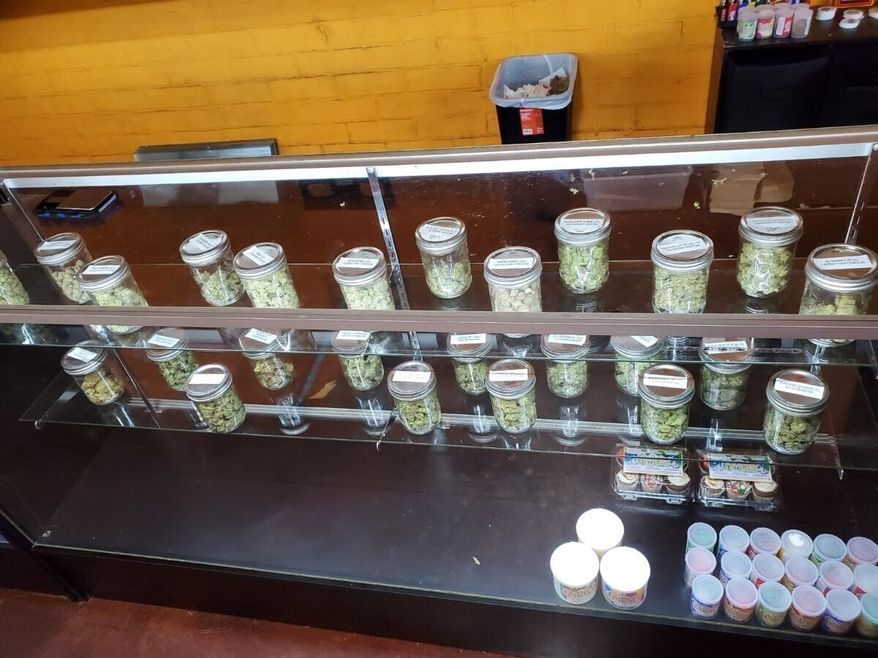 This Thursday, Dec. 12, 2019, photo provided by the Department of Consumer Affairs shows a display with jars of marijuana at Save Greens Cannabis dispensary in Los Angeles. California regulators mounted two-dozen raids against illegal marijuana retailers in Los Angeles this week, the largest crackdown to date against the city's thriving illicit pot market, officials announced Friday, Dec. 13, 2019. (Megan Kiefer/Department of Consumer Affairs via AP)