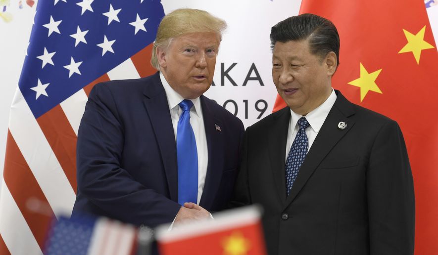 In this June 29, 2019, file photo, U.S. President Donald Trump poses for a photo with Chinese President Xi Jinping during a meeting on the sidelines of the G-20 summit in Osaka, Japan. (AP Photo/Susan Walsh, File) **FILE**