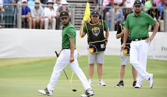 International team player Abraham Ancer of Mexico, left, and playing partner Marc Leishman of Australia, right, survey the 16th green in their foursomes match during the President&#39;s Cup golf tournament at Royal Melbourne Golf Club in Melbourne, Friday, Dec. 13, 2019. (AP Photo/Andy Brownbill)