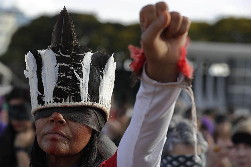 A woman performs the feminist anthem "A rapist in your path," in a demonstration against gender-based violence, in front of the Supreme Court, in Brasilia, Brazil, Friday, Dec. 13, 2019. (AP Photo/Eraldo Peres)