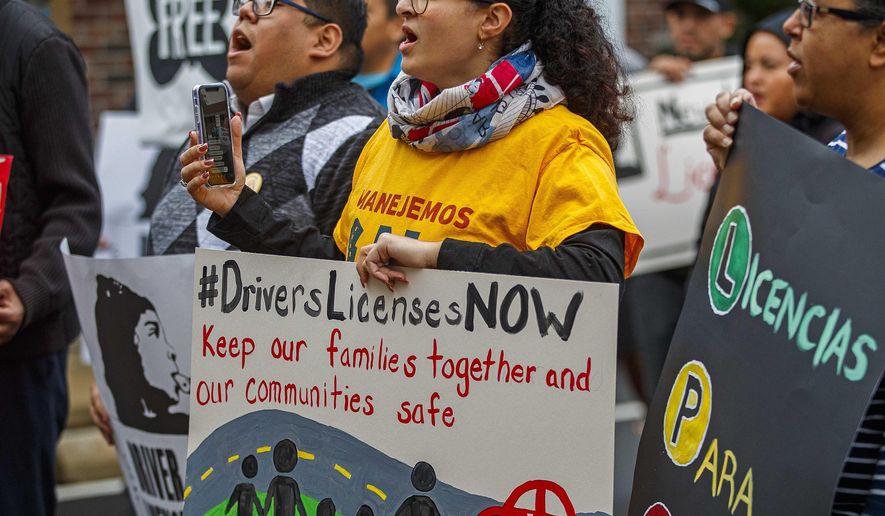 Karina Dominguez, 24, Pleasantville holds a #DriversLicensesNow sign during the rally. Immigrant activists were rallying Tuesday, Dec. 10, 2019, in Northfield, N.J., in front of the offices of Assemblyman Vince Mazzeo and Assemblyman John Armato about Drivers Licenses For Immigrants. (Craig Matthews/The Press of Atlantic City via AP)