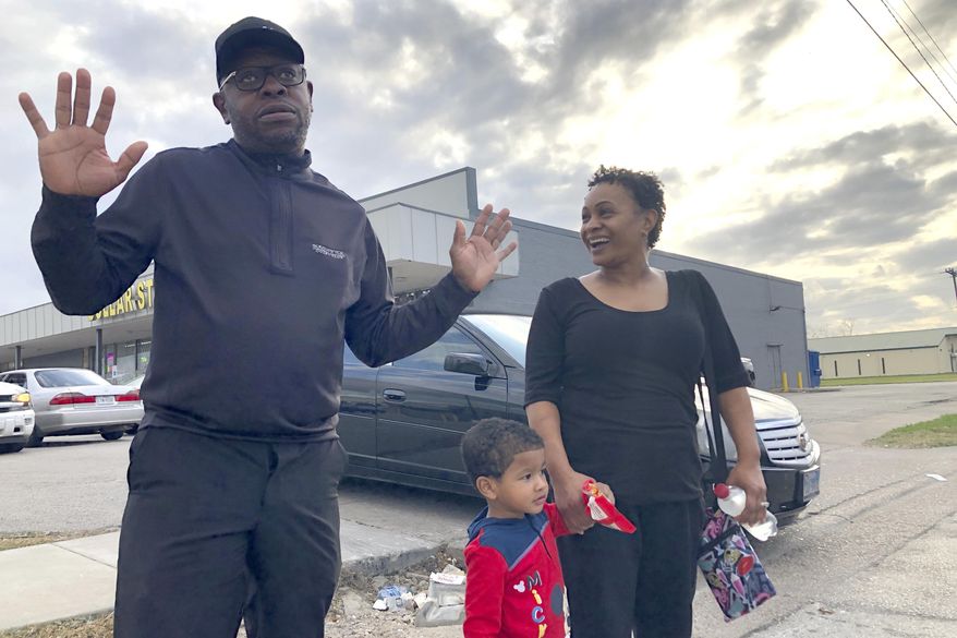 In this Tuesday, Dec. 10, 2019, Rapper turned political candidate, Brad "Scarface" Jordan, left, visits with voter Michele Lemon and her son outside of an early voting location in the Sunnyside neighborhood of Houston, Texas. Jordan is in a run-off against Carolyn Evans-Shabazz for a seat on the Houston City Council. (AP Photo/ John L. Mone)