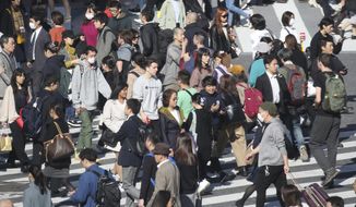 In this Nov. 14, 2019, photo, people cross a street in Tokyo. A closely watched economic survey by the Bank of Japan showed sentiments among major manufacturers soured for the fourth straight quarter, the “tankan” survey released Friday, Dec. 13, 2019. A trade war between the U.S. and China crimped trade and growth. Japan’s growth is dependent on exports and any slowdown in pan-Pacific trade hurts company sentiments. (AP Photo/Koji Sasahara)