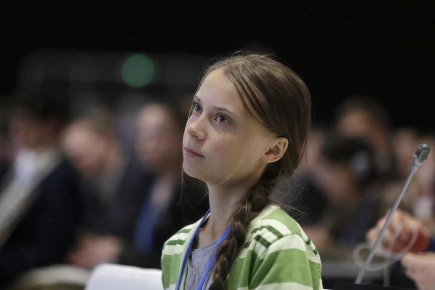 In this Wednesday, Dec. 11, 2019, file photo, Swedish climate activist Greta Thunberg listens to speeches before addressing the U.N. climate conference n Madrid, Spain. (AP Photo/Paul White)