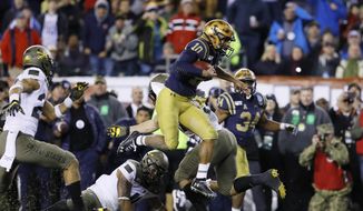 Navy&#39;s Malcolm Perry (10) leaps over Army&#39;s Donavan Lynch (11) during the second half of an NCAA college football game, Saturday, Dec. 14, 2019, in Philadelphia. (AP Photo/Matt Slocum)