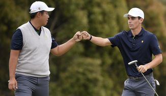 International team player Byeong Hun An of South Korea, left, and playing partner Joaquin Niemann of Chile celebrate on the 12th green in their foursome match during the President&#39;s Cup golf tournament at Royal Melbourne Golf Club in Melbourne, Saturday, Dec. 14, 2019. (AP Photo/Andy Brownbill)