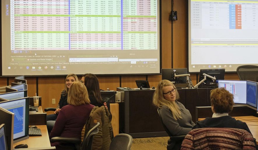 Women involved in agriculture learn about buying and selling farm commodities during a training session at the commodity trading lab in North Dakota State University in Fargo on Dec. 6, 2019. (Dan Gunderson/Minnesota Public Radio via AP)