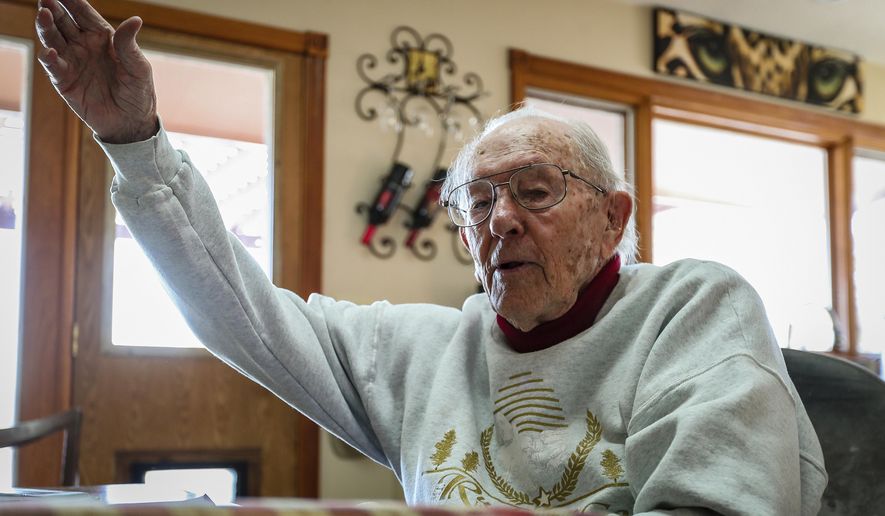 In this Dec. 6, 2019 photo, Richard Wright tells a story about firing a bazooka into a house in Italy while in the 10th Mountain Division during World War II at his home in Piedmont, S.D.  Wright celebrated his 98th birthday on Dec. 10. He observed the 78th Pearl Harbor Day on Dec. 7. Those two dates are related in more than their proximity on the calendar. The attack on Pearl Harbor is what led Wright to join the armed forces. (Adam Fondren /Rapid City Journal via AP)