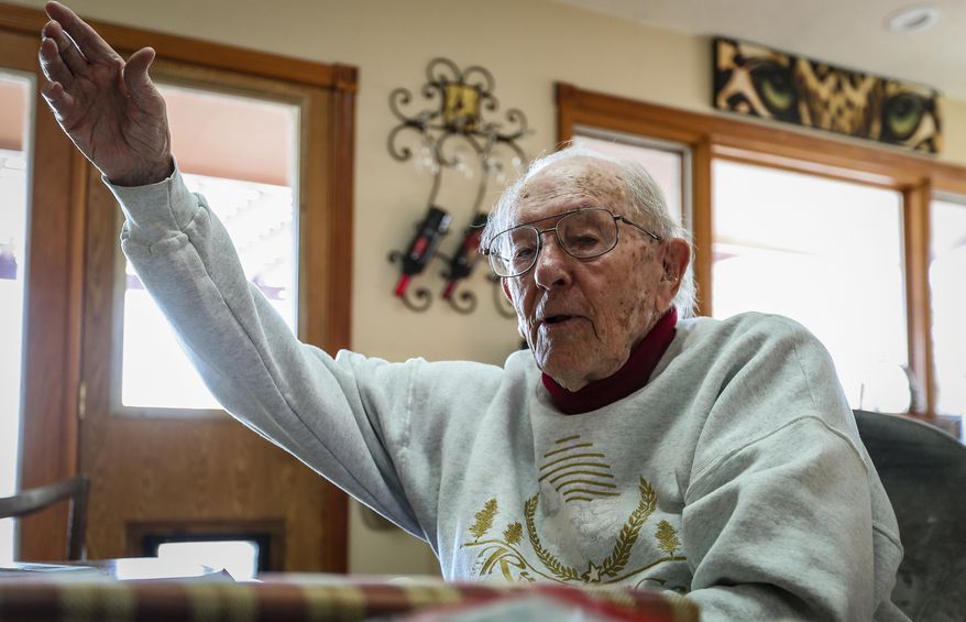 In this Dec. 6, 2019 photo, Richard Wright tells a story about firing a bazooka into a house in Italy while in the 10th Mountain Division during World War II at his home in Piedmont, S.D.  Wright celebrated his 98th birthday on Dec. 10. He observed the 78th Pearl Harbor Day on Dec. 7. Those two dates are related in more than their proximity on the calendar. The attack on Pearl Harbor is what led Wright to join the armed forces. (Adam Fondren /Rapid City Journal via AP)