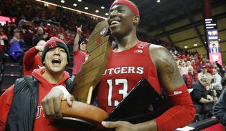 Rutgers forward Shaq Carter (13) celebrates with the Garden State Hardwood Classic trophy after Rutgers upset Seton Hall in an NCAA college basketball game, Saturday, Dec. 14, 2019, in Piscataway, N.J. Rutgers defeated Seton Hall 68-48. (AP Photo/Kathy Willens)