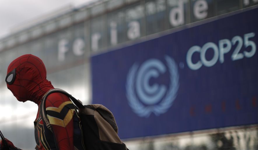 A man dressed in a Spiderman costume walks outside of the COP25 climate talks congress in Madrid, Spain, Saturday, Dec. 14, 2019.  The United Nations Secretary-General has warned that failure to tackle global warming could result in economic disaster. (AP Photo/Manu Fernandez)