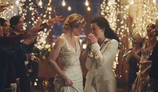 This image made from undated video provided by Zola shows a scene of its advertisement. The Hallmark Channel says it will reinstate same-sex marriage commercials that it had pulled from the network. Hallmark Cards CEO Mike Perry said in a statement Sunday, Dec. 15, 2019, that pulling the commercials was the wrong decision.&quot;  (Zola via AP)