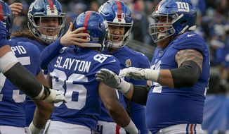 New York Giants wide receiver Darius Slayton (86) celebrates with quarterback Eli Manning (10) and other teammates after scoring a touchdown against the Miami Dolphins during the third quarter of an NFL football game, Sunday, Dec. 15, 2019, in East Rutherford, N.J. (AP Photo/Seth Wenig)
