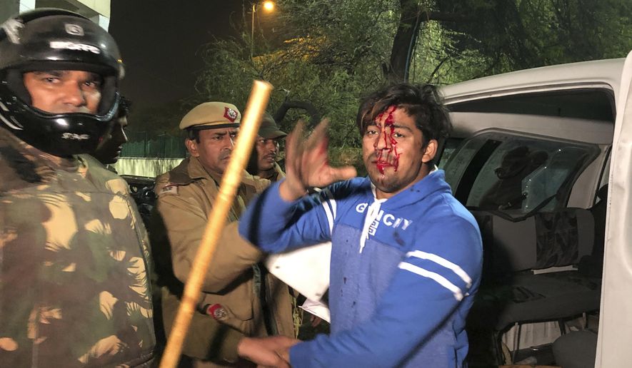 Policemen detain an injured student outside Jamia Millia Islamia university during a protest against Citizenship Amendment Act in New Delhi, India, Sunday, Dec. 15, 2019. Protests have been continuing over a new law that grants Indian citizenship based on religion and excludes Muslims. (AP Photo/Saaliq Sheikh)