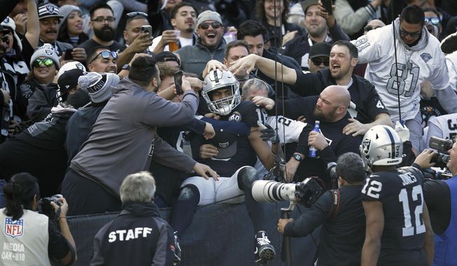 Oakland Raiders wide receiver Tyrell Williams is mobbed by fans after scoring a touchdown during the first half of an NFL football game against the Jacksonville Jaguars in Oakland, Calif., Sunday, Dec. 15, 2019. (AP Photo/Ben Margot)