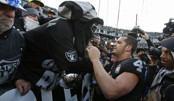Oakland Raiders quarterback Derek Carr (4) is met by Gorilla Nilla in &amp;quot;The Black Hole&amp;quot; at the end of an NFL football game against the Jacksonville Jaguars in Oakland, Calif., Sunday, Dec. 15, 2019. (AP Photo/D. Ross Cameron)