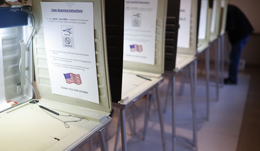 In this Nov. 8, 2016, file photo a lone voter fills out a ballot alongside a row of empty booths at a polling station in the Terrace Park Community Building on Election Day in Cincinnati, Ohio. A federal judge on Friday, Dec.27, refused to intercede to stop the state of Georgia from cleaning up its voter registration list to remove around 120,000 inactive voters. (AP Photo/John Minchillo, File) **FILE**