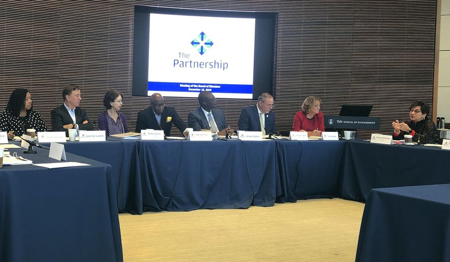 Yvette Melendez, right, addresses fellow members of The Partnership for Connecticut board of directors, including Gov. Ned Lamont, second from left, at the group's second meeting, held at Yale University, Monday, Dec. 16, 2019, in New Haven, Conn. The partnership is working to narrow the focus of the education nonprofit, which is funded partly by taxpayer funds and by contributions from Dalio Philanthropies, the family foundation of the founder of the world's largest hedge fund. (AP Photo/Susan Haigh)